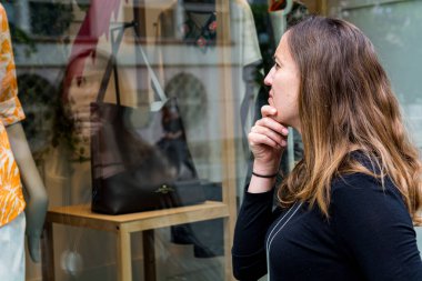 Çekici esmer vitrin alışverişi butiğe bakıyor..