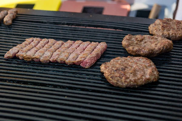 Deliziosa carne macinata cevapcici e pleskavice su una griglia . — Foto Stock