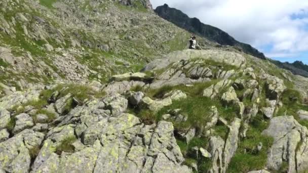 Замедленная съемка с воздуха, где женщина-туристка исследует впечатляющий горный ландшафт . — стоковое видео
