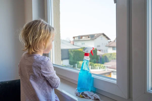 Söt flicka rengöring fönster i hennes rum. — Stockfoto