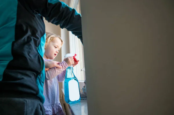 Söt flicka som hjälper mamma att rengöra fönster. — Stockfoto