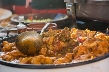 Aşçı büyük bir tencerede lezzetli et yemeği pişiriyor..