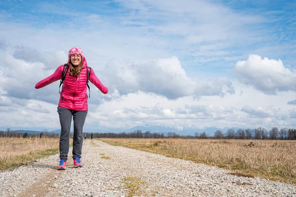 Junge Frau posiert auf Feldweg inmitten von Feldern. — Stockfoto