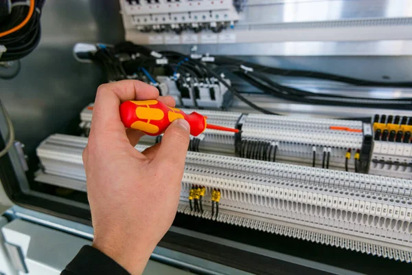 Engenheiro elétrico verificando cubículo elétrico e fixando tiras de conector . — Fotografia de Stock