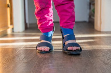 Annesinin yüksek topuklu ayakkabılarıyla yürüyen genç kızın detaylı görüntüsü..