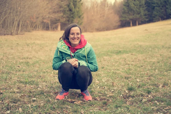 Mulher caucasiana feliz sentado no prado da floresta conteúdo com ela mesma . — Fotografia de Stock