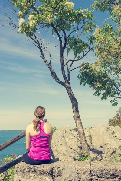 Active woman sitting and enjoying sea view. Living life and meditating. — Stock Photo, Image