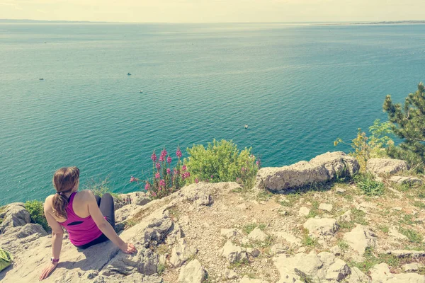Mulher ativa sentado e desfrutando de vista para o mar. Viver a vida e meditar . — Fotografia de Stock