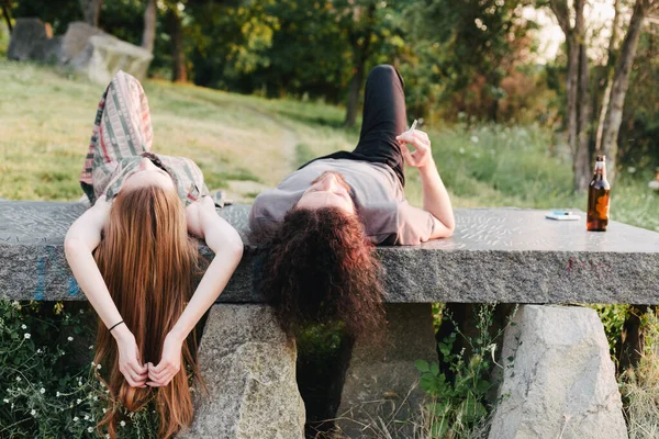 Couple lying in the park, enjoying the time together. Boyfriend smoking — Stock Photo, Image