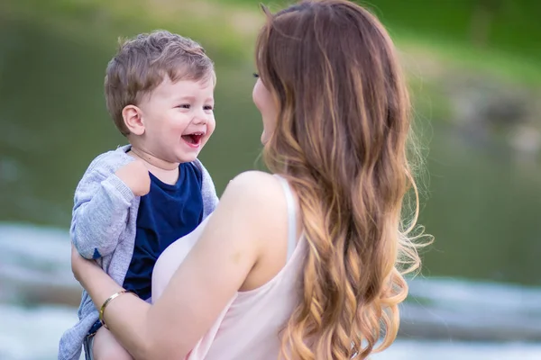 Mãe segurando seu lindo filho loiro, amor e carinho. Dia de crianças universal — Fotografia de Stock