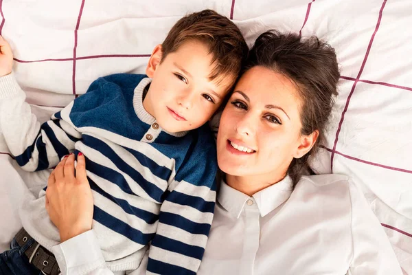 Mom and her son lying in bed, enjoying their time together. — Stock Photo, Image