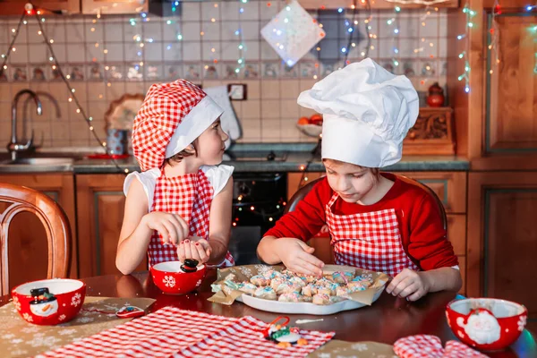 Cute, little girls in chef uniform with apron and hat making ginger cookies. — Stock Photo, Image