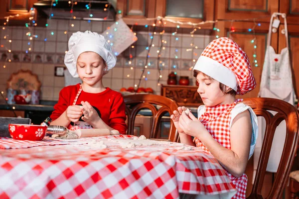 Cute, little girls in chef uniform with apron and hat making ginger cookies — Stock Photo, Image