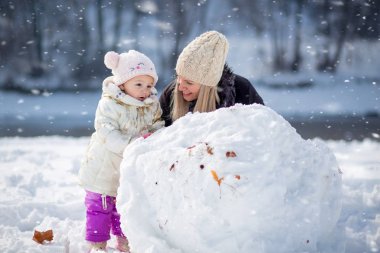 Mutlu aile, kızı olan anne, kış zamanı, açık hava aktivitesi.