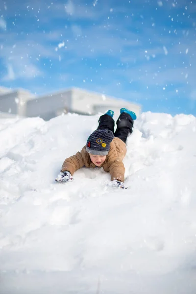男孩玩得开心，在外面玩，被雪包围着。冬季 — 图库照片