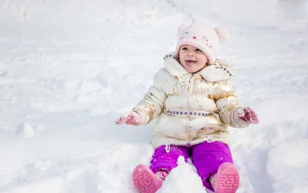 小女孩在白色夹克有乐趣，在外面玩，被雪包围. — 图库照片