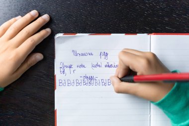 Kiril alfabesi mektupları yazan bir çocuk. Sırpça ödev öğrenen yeni mektuplar yazıyor.