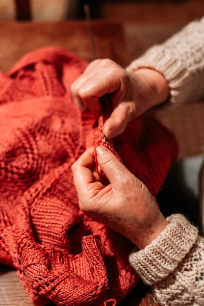 Las manos de una mujer mayor, tejiendo suéter rojo. Hobby y ocio — Foto de Stock