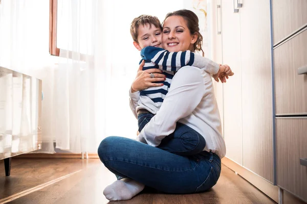 Beautiful young mom and her son hugging each other tightly. — Stock Photo, Image