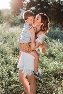 Sarışın oğlunu kollarında tutan güzel bir anne. Anneler Günü