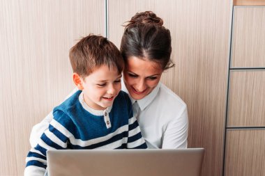 Anne ve oğlu, yerde oturmuş dizüstü bilgisayara bakıyorlardı. Birisiyle görüntülü konuşma