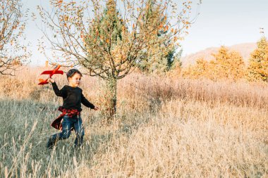 Çocuk parkta kırmızı uçak oyuncağıyla oynuyor. Çocuk aktivitesi