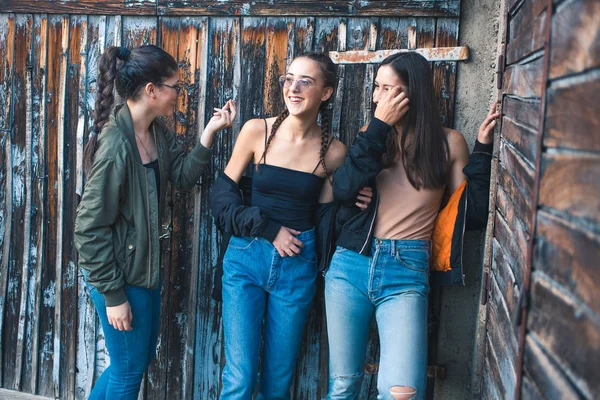 Three teenage girls, friends standing in front of the retro wooden door, garage. — Stock Photo, Image