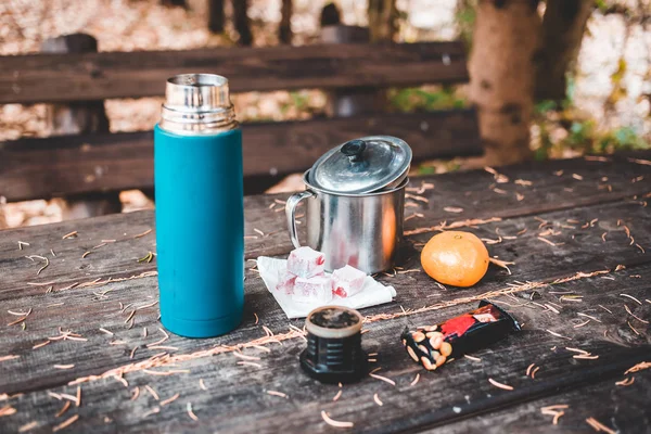 Thermos with coffee, chocolate bar, orange and Turkish delight on wooden table. — 스톡 사진