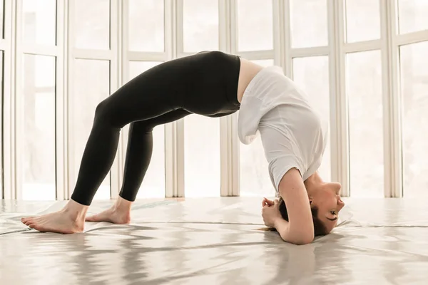 Hermosa mujer entrenadora de yoga. Concepto de yoga. Puente pose —  Fotos de Stock