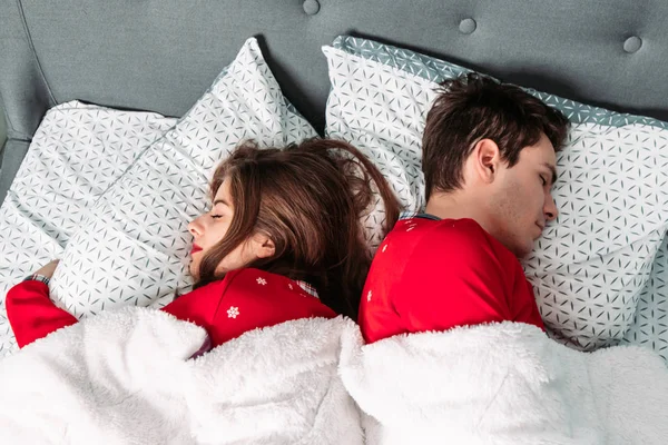 Para leżąca w łóżku w czerwonej piżamie. Walentynki — Zdjęcie stockowe