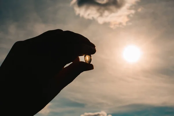 Ručně držící rybí tuk vitamín D průhledné tobolky. Doplňky stravy — Stock fotografie