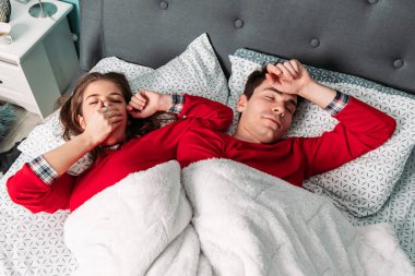 Cute couple waking up in the morning together. Yawning and stretching