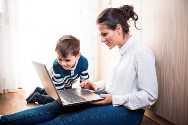 Anne ve oğlu, yerde oturmuş dizüstü bilgisayara bakıyorlardı. Birisiyle görüntülü konuşma