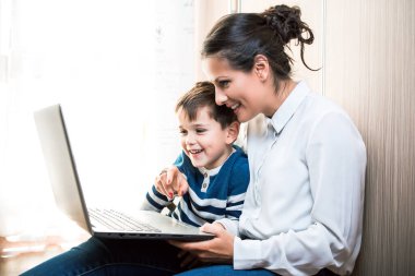 Anne ve oğlu, yerde oturmuş dizüstü bilgisayara bakıyorlardı. Birisiyle görüntülü konuşma