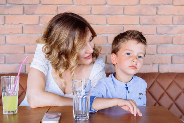 Mom is looking at son, telling him something, he looks like he doesn not care. — Stock Photo, Image