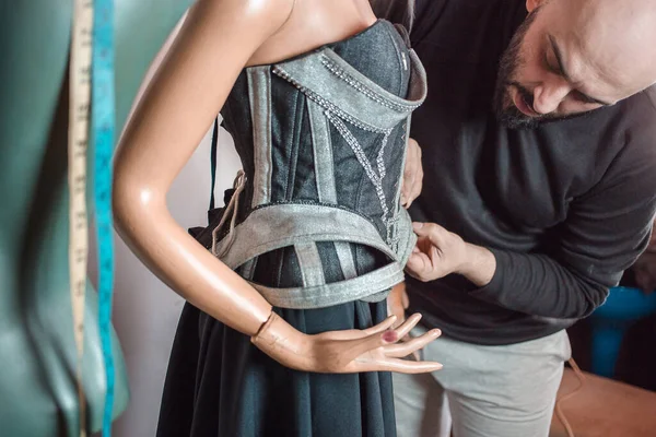 Moda tasarımcısı onun yeni yaratılış üzerinde çalışıyor. Güzel mavi korse.