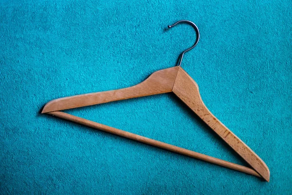 Wooden clothes hanger isolated on the blue carpet floor — 스톡 사진