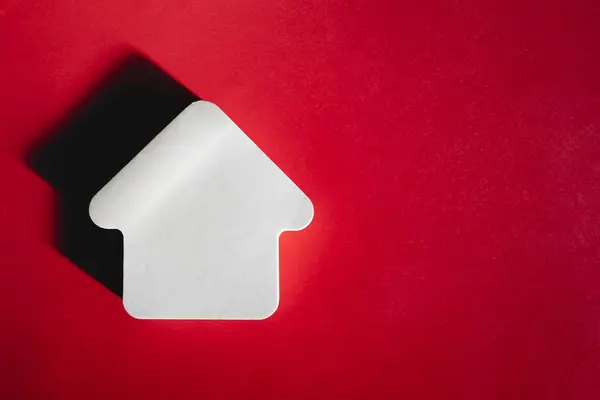 赤い背景に白い家のフレームを空にします。住宅購入のコンセプト — ストック写真