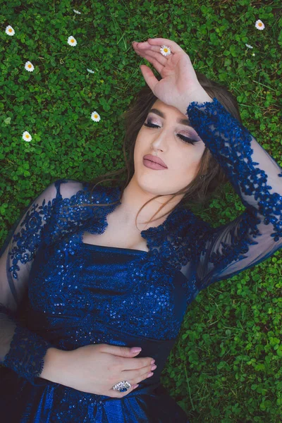 Gyönyörű lány elbűvölő ultrahangos ruhában feküdt a fűben.. — Stock Fotó