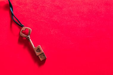 Kırmızı arkaplanda kalp detaylarıyla anahtar şekilli usb çubuğu