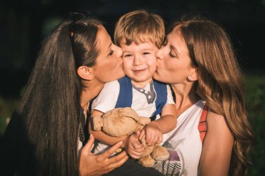 Anne ve teyze kucaklaşıp öpüşüyorlar, tatlı çocuk. Aile sevgisi