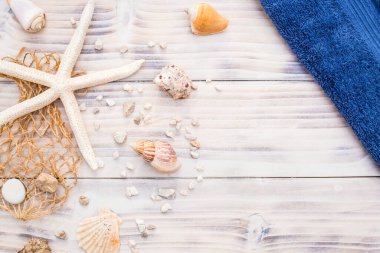 Beyaz ahşap arka planda deniz kabukları olan denizyıldızı. Yaz saati, tatil konsepti, mavi havlu ile hediyelik eşya