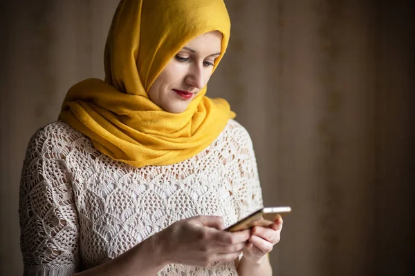 Nowoczesna Muzułmanka Żółtym Szalikiem Patrząca Telefon Koncepcja Różnorodności — Zdjęcie stockowe