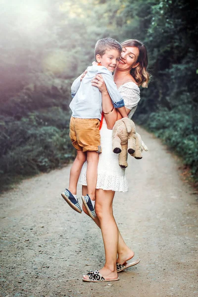 美しい若いお母さんが息子を抱いている 自然散策 — ストック写真