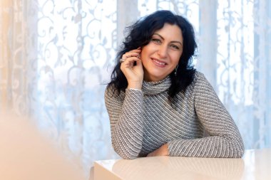 Gülümseyen orta yaşlı güzel bir kadın. Kapalı alan fotoğrafı