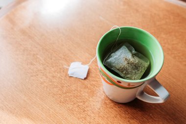 Tahta masadaki çay fincanının üst görüntüsü. Sağlıklı alışkanlıklar. Metin için boşluk