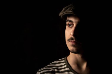 Bıyıklı, siyah şapkalı, esmer, yakışıklı bir genç adam portresi. Boşluğu kopyala, metin için boşluk