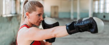 Güzel sarışın kız boksör. Direkt yumruk. Aktif yaşam tarzı. Geniş, pankart biçimi