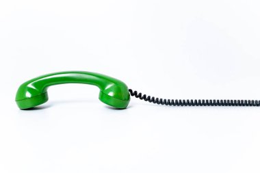 Eski yeşil telefon kulaklığı. Kablosu bükülmüş. Beyaz arka planda izole edilmiş. Boşluğu kopyala, yazmak için boşluk