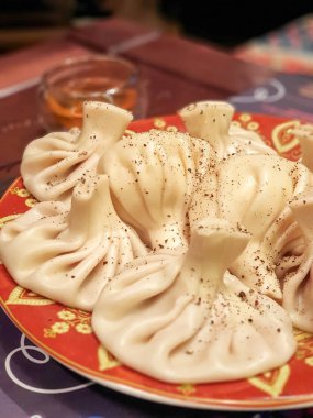 Farklı şekillerde güzel bir tabakta baharatlı lezzetli khinkali.